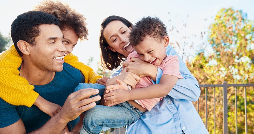 Mixed race family hugs outdoors